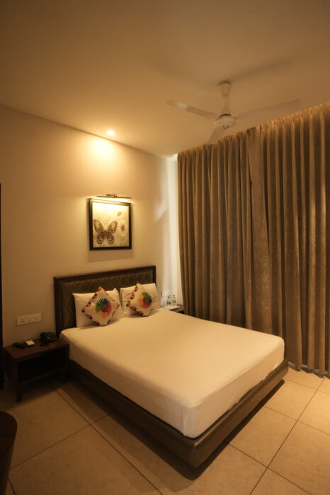 Deluxe room at Hotel Kasauli Regency, Kasauli, with double bed and floor-length curtains