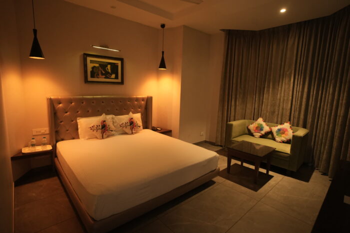 Super Deluxe room at Hotel Kasauli Regency, Kasauli, with king bed, sofa and warm pendant lights